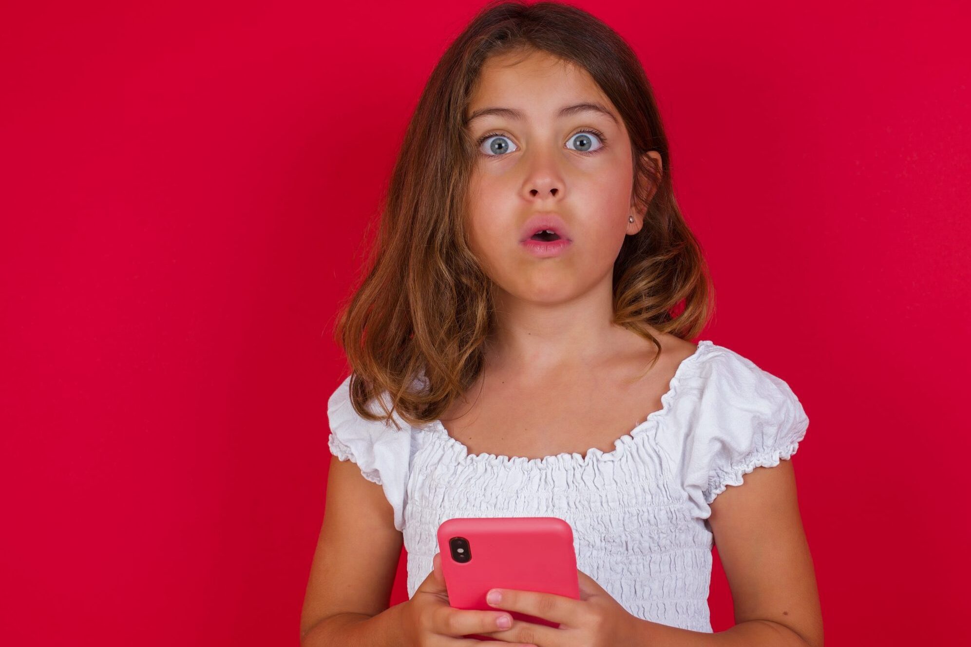 Young girl surprised by what she's seen on her smartphone