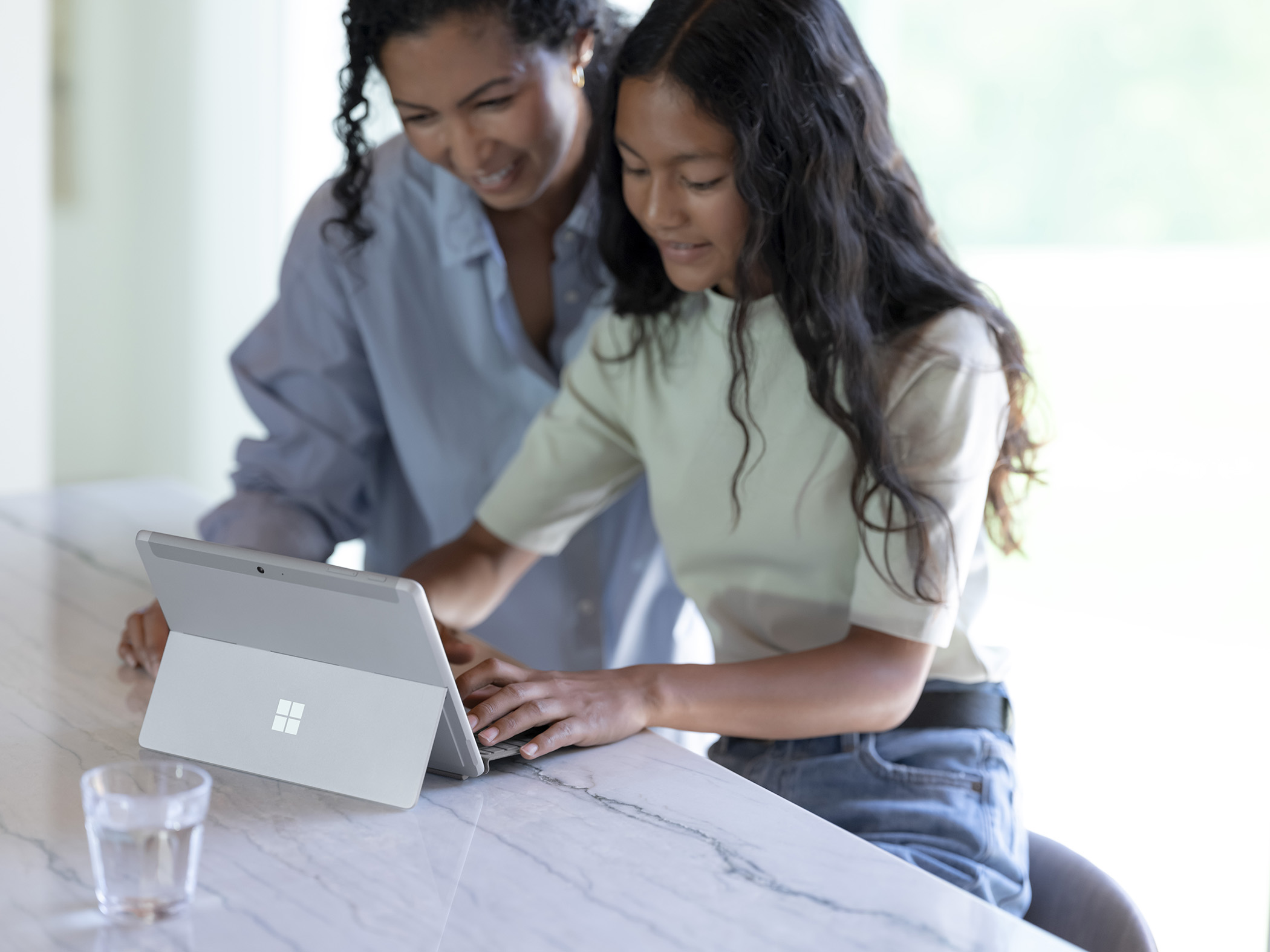 illustrative photo of a family using a Microsoft Surface Go 3 on a desk